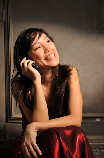 Asiatische Chinesin in rotem Kleid telefoniert — Stockfoto