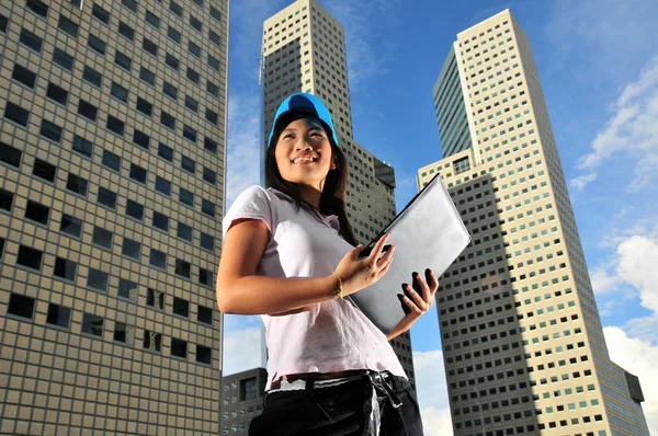 Здоровая азиатка сладко улыбается перед офисными зданиями — стоковое фото
