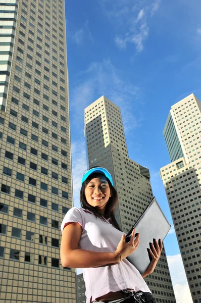 Здоровая азиатка сладко улыбается перед офисными зданиями — стоковое фото