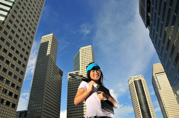 Азиатская здоровая девушка держит теннисную ракетку на открытом воздухе — стоковое фото