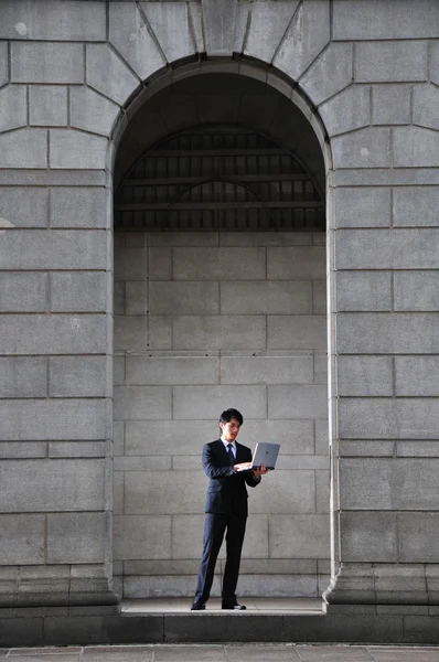 Asian Chinese Man standing in the arch of a roman architecture — Stock Photo, Image