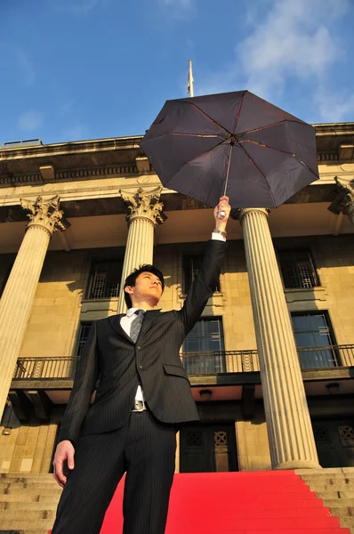 Концептуальная фотография азиатского человека с зонтиком — стоковое фото