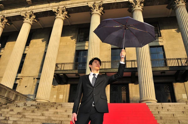 Konceptuální pic z asijského muže s deštníkem — Stock fotografie