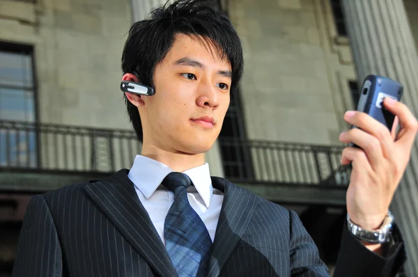Asiático chinês homem com seus dispositivos de telecomunicações — Fotografia de Stock