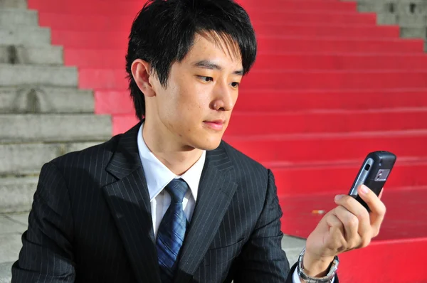 Asiático chinês homem com seus dispositivos de telecomunicações — Fotografia de Stock