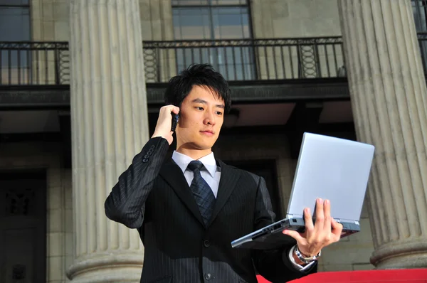 Ejecutivo chino asiático con ordenador portátil y otros dispositivos móviles — Foto de Stock