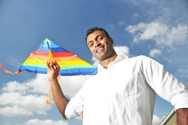 印度男子持有一个满面笑容的彩虹风筝 — 图库照片