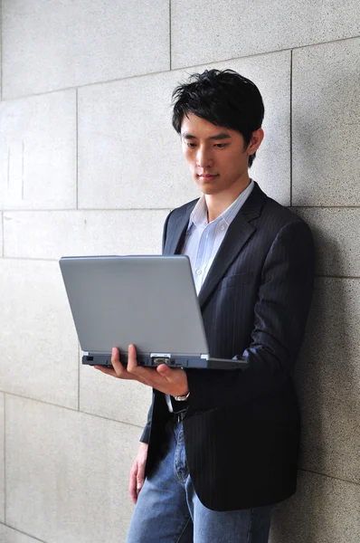 Студент-азиат с ноутбуком — стоковое фото