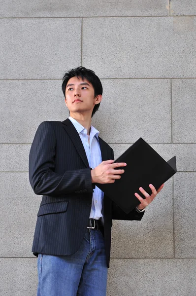 Asian Professional holding clipboard and thinking — Stock Photo, Image