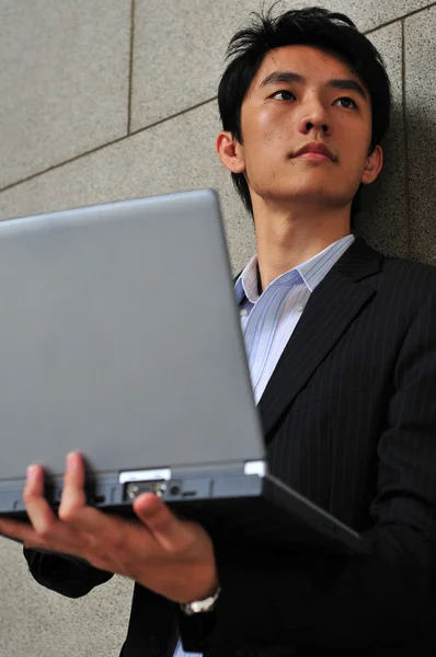 Asiático estudiante con un portátil buscando entusiasta — Foto de Stock