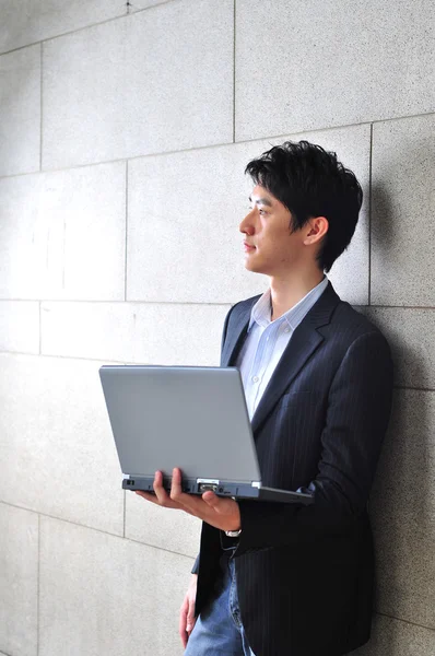 Aziatische student met een laptop op zoek naar enthousiaste — Stockfoto