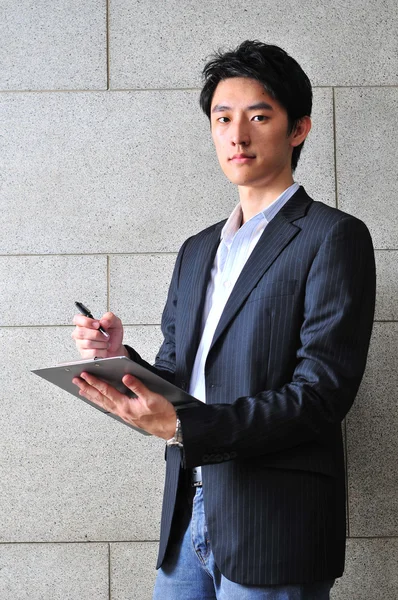 Asiatico studente writing giù un memo — Foto Stock