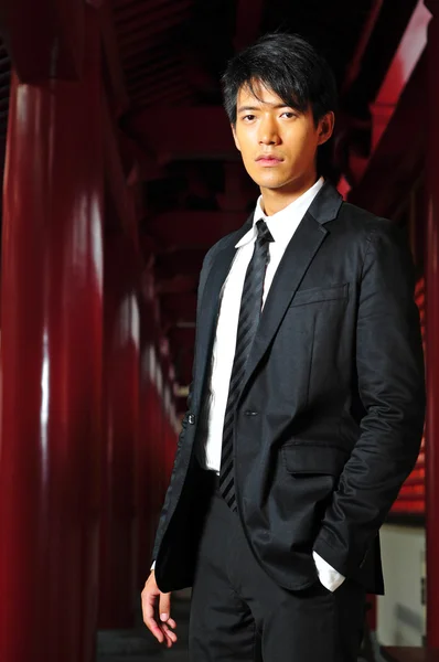 Ασιατικές νεαρός άνδρας, που στέκεται μπροστά από ένα ναό — Φωτογραφία Αρχείου