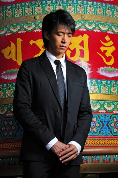 Ασιατική άνθρωπος στέκεται μπροστά από βουδιστές ή επιγραφή του Θιβέτ — Φωτογραφία Αρχείου