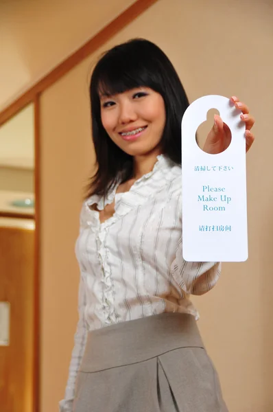 Asiatico donna holding su hotel signage — Foto Stock