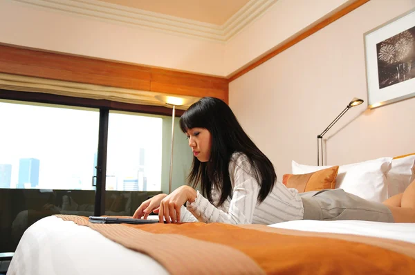 Beautiful chinese office lady working in her hotel room — Stock Photo, Image
