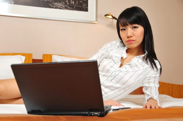 Schöne chinesische Bürodame arbeitet in ihrem Hotelzimmer — Stockfoto