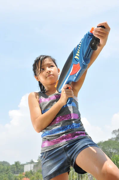 Asiatisk kinesisk ung tjej leker med en vatten pistol — Stockfoto