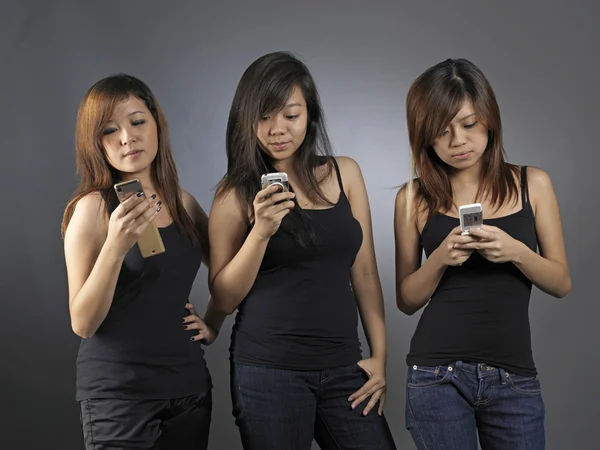 Ασιατικές έφηβες χρησιμοποιώντας τα κινητά τους τηλέφωνα — Φωτογραφία Αρχείου