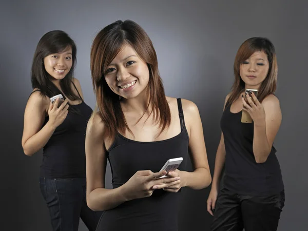 Aziatische chinese meisjes groep met behulp van hun mobiele telefoons — Stockfoto