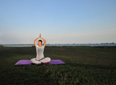 Asian chinese lady practise yoga near the sea clipart