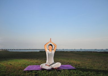 Asyalı Çinli Bayan pratik yoga denize yakın