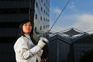 Asian chinese female fencer in the city clipart