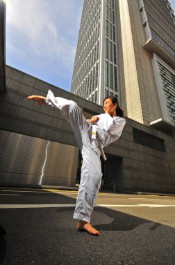 Asian chinese lady in karate gear in the city district clipart