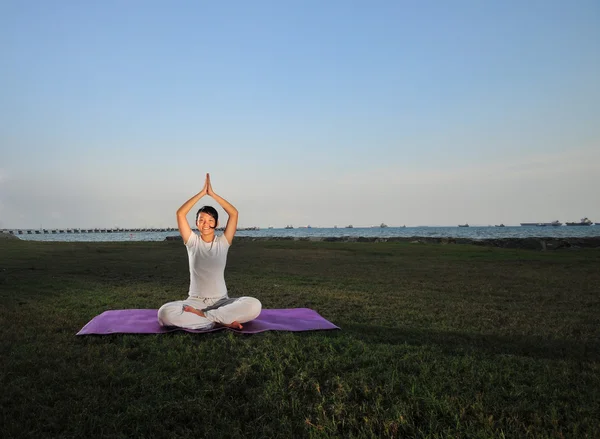 Asiática china dama practica yoga cerca del mar —  Fotos de Stock