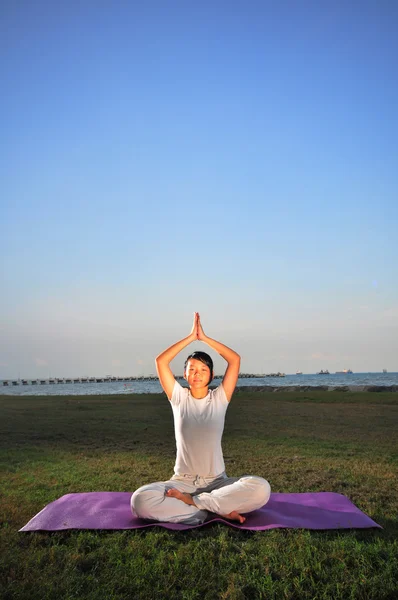 Asiatische chinesische Dame praktiziert Yoga in der Nähe des Meeres — Stockfoto