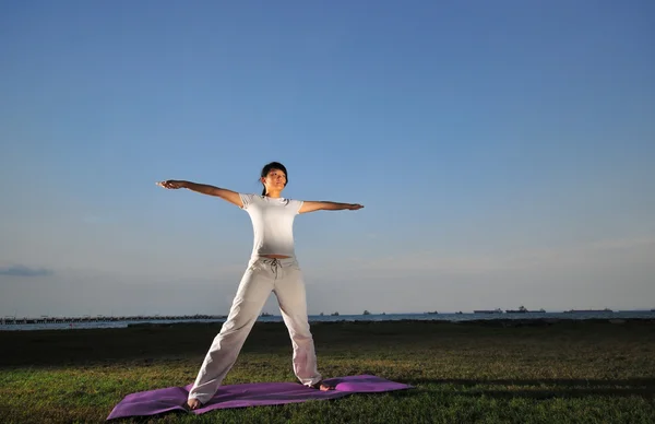 Asiatisk kinesisk Dam utöva yoga nära havet — Stockfoto