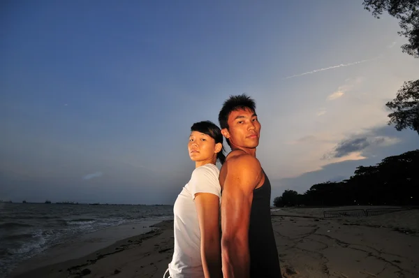 Asiatiska kinesiska par poserar på strandenアジアの中国のカップル、ビーチでポーズ — Stockfoto