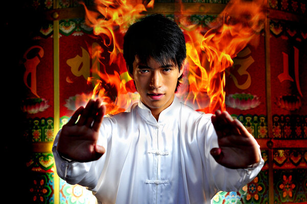 Asian Chinese Man in flames emerging at high point of kung fu