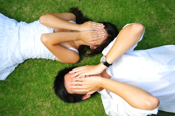 Китайська пару лежить на траві з різних виразів — стокове фото