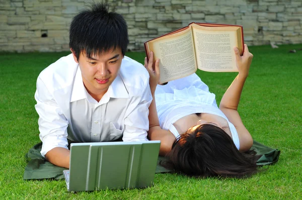 Ασιατική ζευγάρι ανάγνωση στο πάρκο — Φωτογραφία Αρχείου