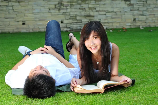Asian chinese couple reading in the park — Stock Photo, Image