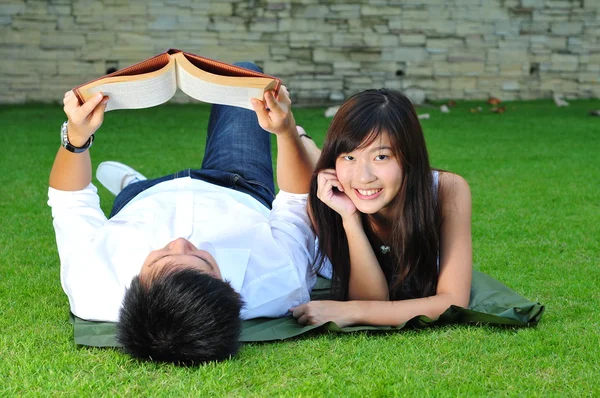 Asian chinese couple reading in the park — Stock Photo, Image
