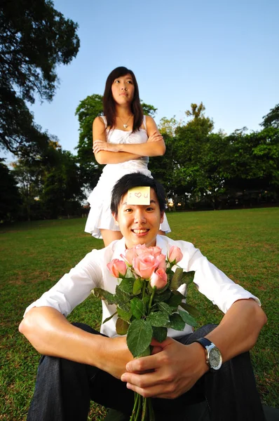 Азіатський пар в саду, дражнять один одного — стокове фото