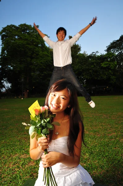 Asiático parejas en un jardín burlas unos a otros — Foto de Stock