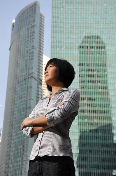 Ambiziosa giovane donna asiatica con edifici sullo sfondo — Foto Stock