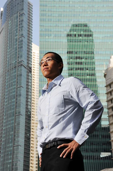 Ambitiös ung asiatisk man med byggnader i bakgrunden — Stockfoto