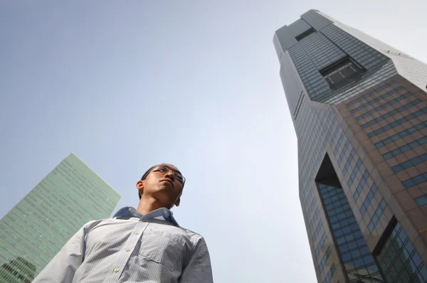 Ehrgeiziger junger asiatischer Mann mit Gebäuden im Hintergrund — Stockfoto