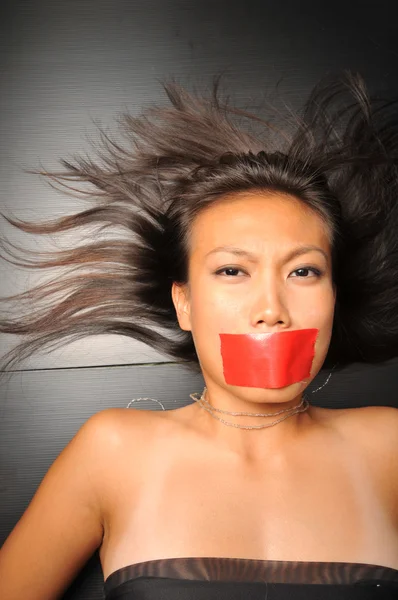 Asiatisk kinesisk flicka med tejp över munnen — Stockfoto