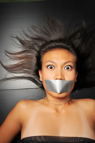 Asian chinese girl with tape over her mouth — Stock Photo, Image