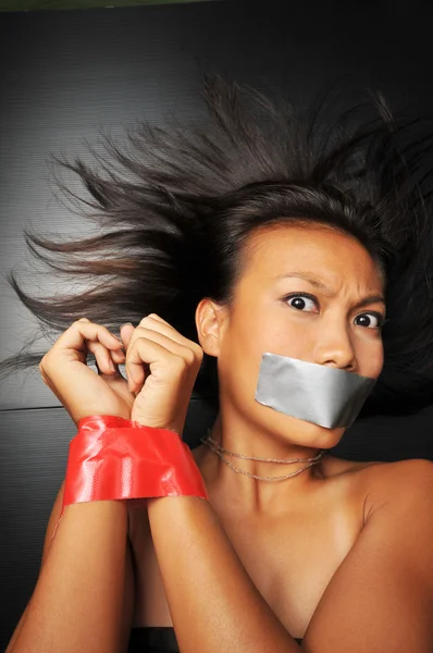 Asian chinese girl with tape over her mouth Stock Photo
