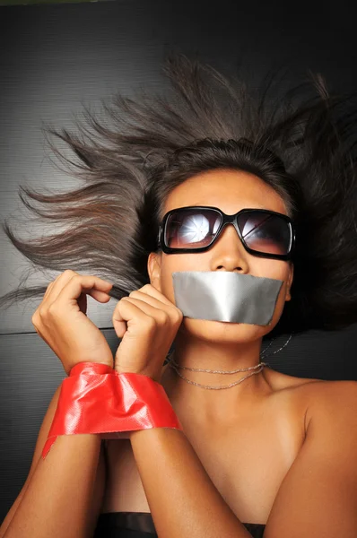 Asian chinese girl with tape over her mouth Stock Image