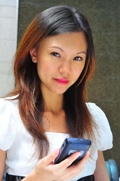 Азиатская официантка использует свой мобильный коммуникатор — стоковое фото