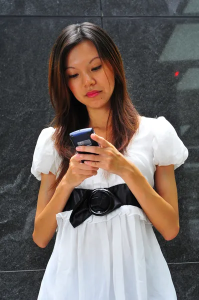 Азиатская официантка использует свой мобильный коммуникатор — стоковое фото