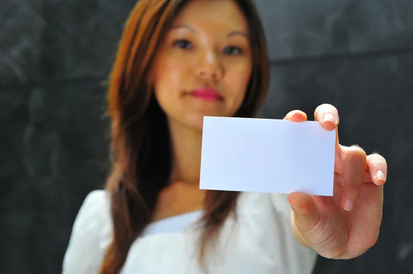 Sonriente asiática china chica sosteniendo un namecard —  Fotos de Stock