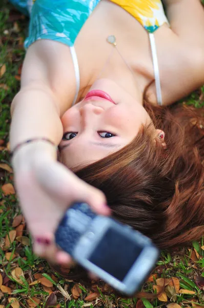 Asiática china chica acostada en la hierba con su teléfono — Foto de Stock